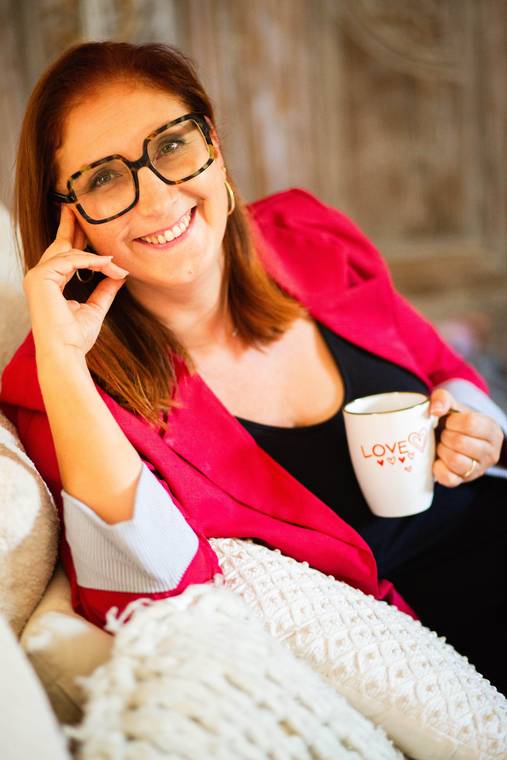 Cécile Pagès sourit, installée dans un canapé, une tasse à la main